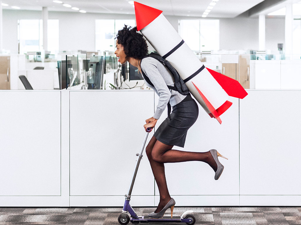 Woman with Rocket Backpack on Scooter in Office